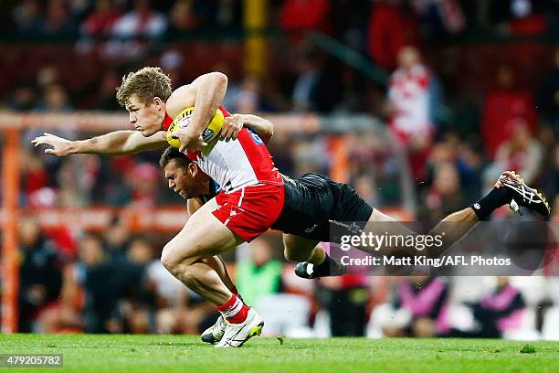 Luke Parker of the Swans is tackled by Nathan Krakouer of the Power during the round 14 AFL match between the Sydney Swans and the Port Adelaide...