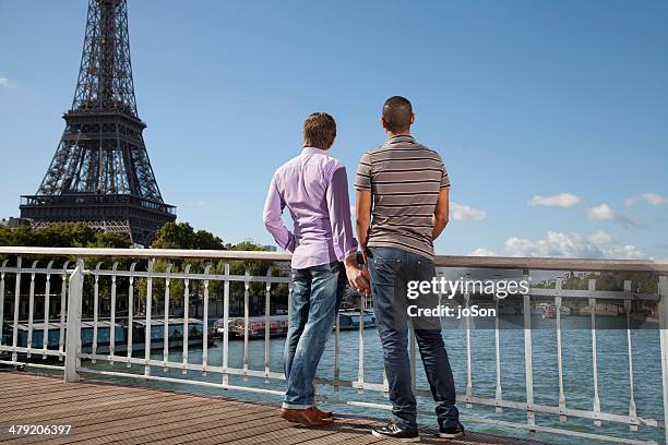 gay couple holding hands in ,paris - couple paris tour eiffel trocadero stock-fotos und bilder