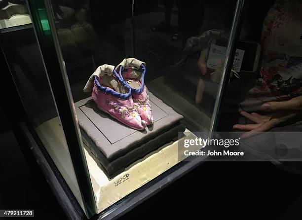 Tiny pair of shoes made for a woman's bound feet sits on display at the Shu Embroidery Museum on June 28, 2015 in Chengdu, China. Foot binding to...