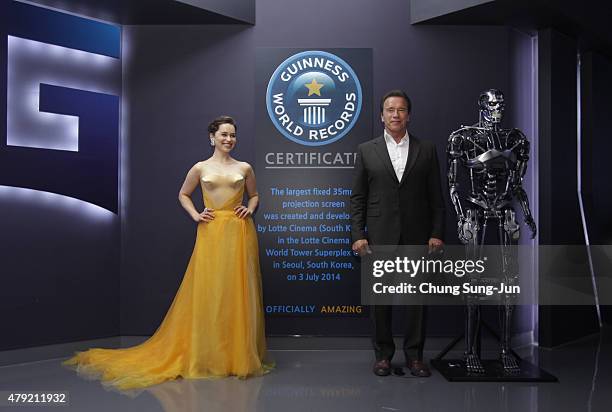 Emilia Clarke and Arnold Schwarzenegger pose in front of the sign a listed in the Guinness book of records as largest theater screen in the world...