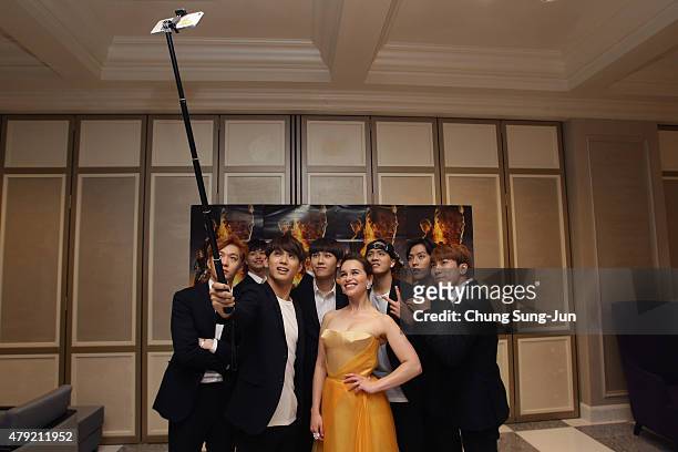 Emilia Clarke poses with South Korean Idol group BtoB for a selfie during the Seoul Premiere of 'Terminator Genisys' at the Lotte World Tower Mall on...