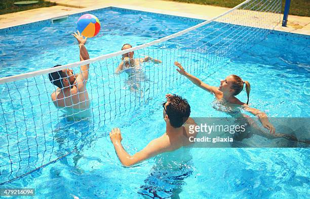 friends playing volleyball in a pool. - lido stock pictures, royalty-free photos & images
