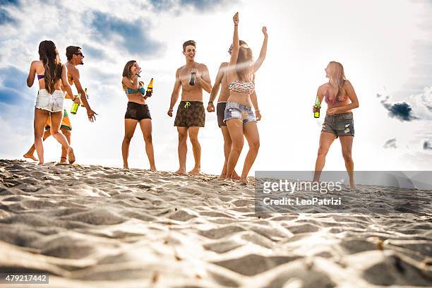 friends having a party on the beach at dusk - lens flare young people dancing on beach stock pictures, royalty-free photos & images