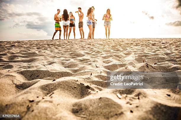 friends having a party on the beach at dusk - lens flare young people dancing on beach stock pictures, royalty-free photos & images