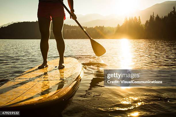 パドルボードの中の湖の日の出や夕暮れ時。 - paddleboarding ストックフォトと画像