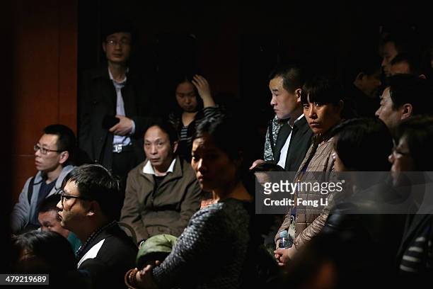 Chinese relatives of the missing passengers who were travelling onboard Malaysia Airlines flight MH370 watch a television displaying a Malaysian...