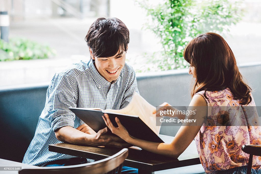 Young couple looking at menu in cafe.