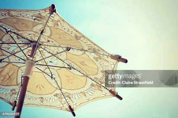 a small lace parasol held up to a bright blue sky - lace parasol stock pictures, royalty-free photos & images