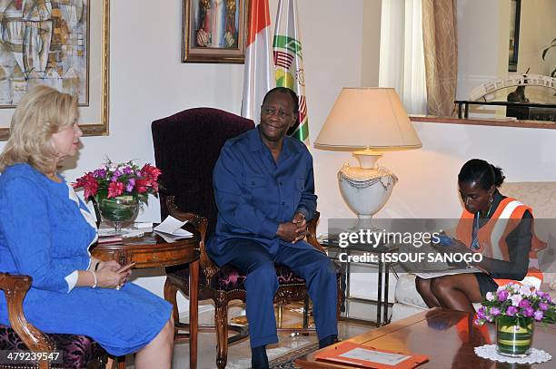 Ivorian President Alassane Ouattara and his wife Dominique talk with a census taker at his home in Abidjan on March 17, 2014. The census of the...