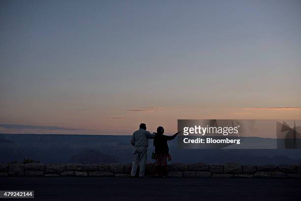 Visitors look out at sunrise from Hopi Point in Grand Canyon National Park in Grand Canyon, Arizona, U.S., on Thursday, June 25, 2015. The Grand...