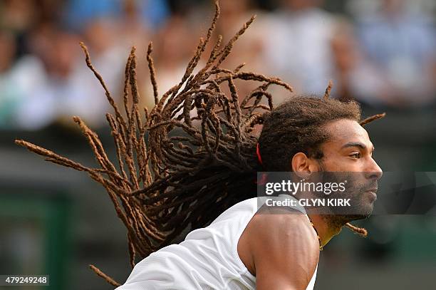 Germany's Dustin Brown serves against Spain's Rafael Nadal during their men's singles second round match on day four of the 2015 Wimbledon...