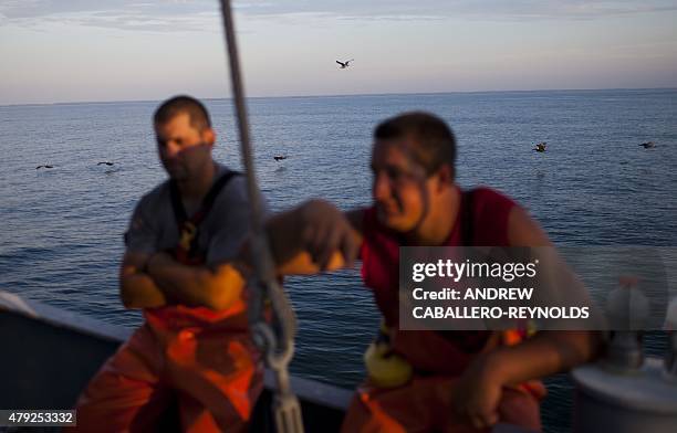 Omega Protein fisherman Samuel Somers and Justin Cammarata take a break between fishing on the 'Reedville' off the coast of Smith Island, Virginia on...