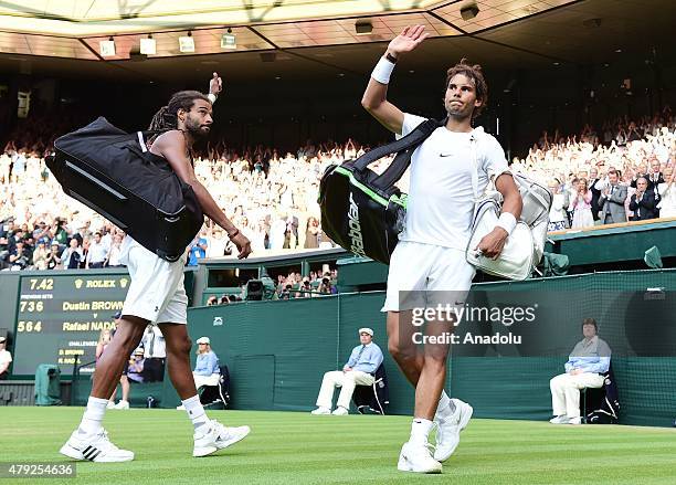 Dustin Brown of Germany and Rafael Nadal of Spain leave the pitch after their match during day four of the Wimbledon Lawn Tennis Championships at the...