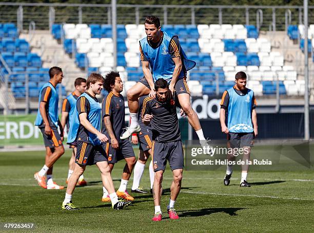 Cristiano Ronaldo of Real Madrid jumps over his teammate's shoulders Angel Di Maria during a training session ahead of their UEFA Champions League...