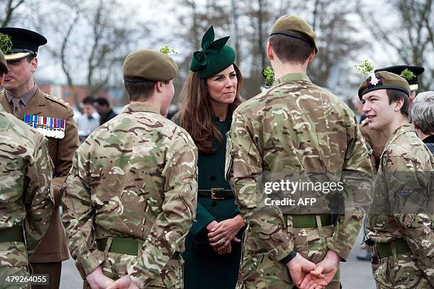 Catherine, Duchess of Cambridge speak with soldiers while visiting the Irish Guards during a St Patrick's Day parade in Mons Barracks in Aldershot on...