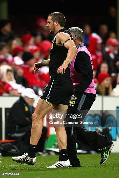 Travis Boak of the Power is assisted from the field during the round 14 AFL match between the Sydney Swans and the Port Adelaide Power at SCG on July...
