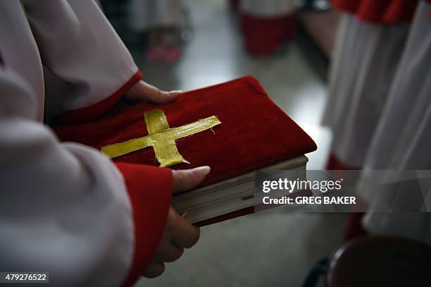 China-religion-politics-Catholic,FEATURE by Tom HANCOCK This photo taken on May 24, 2015 shows an altar server holding a text during a celebration of...