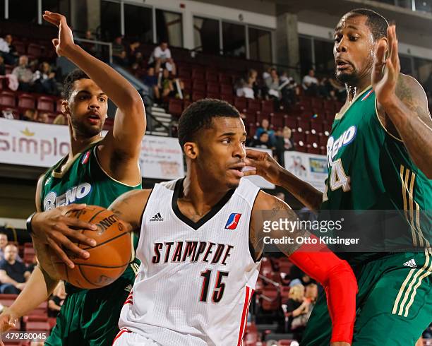 Vander Blue of the Idaho Stampede moves the ball around Trent Lockett and Mickell Gladness of the Reno Bighorns during an NBA D-League game on March...