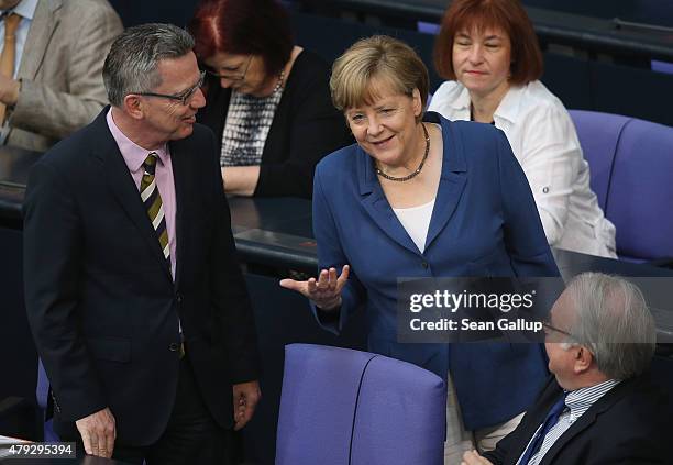 German Chancellor Angela Merkel chats with Interior Minister Thomas de Maiziere as she arrives for a session of the Bundestag on July 3, 2015 in...