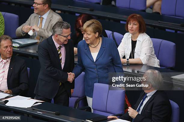 German Chancellor Angela Merkel chats with Interior Minister Thomas de Maiziere as she arrives for a session of the Bundestag on July 3, 2015 in...