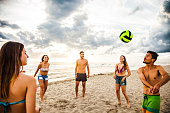 Group of friend play volley on the beach