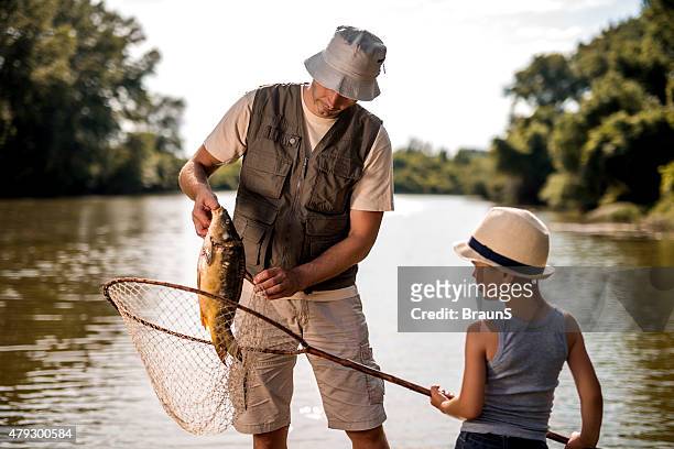 trabajo en equipo de agua e hijo sobre la pesca. - carp fotografías e imágenes de stock
