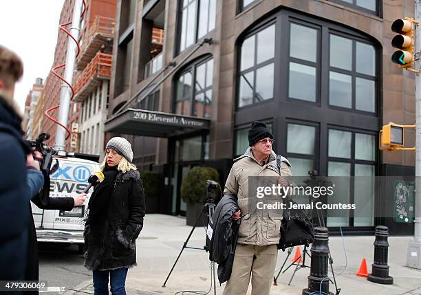 Media crews conduct interviews outside the Chelsea apartment building where fashion designer L'Wren Scott was found dead from an apparent suicide on...