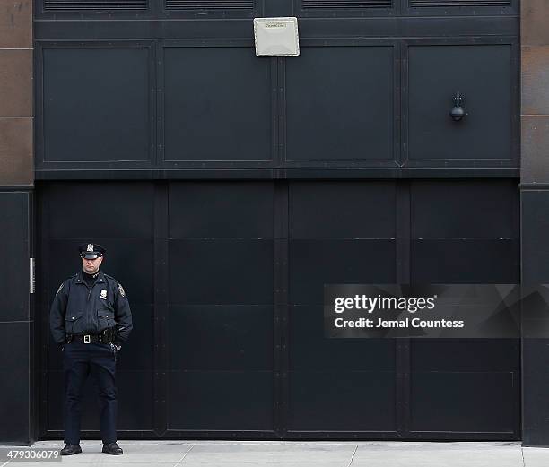 Police officer guards the garage entrance to the Chelsea apartment where fashion designer L'Wren Scott was found dead earlier from an apparent...