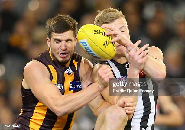 Ben Stratton of the Hawks and Jordan De Goey of the Magpies collide whilst going for a mark during the round 14 AFL match between the Collingwood...