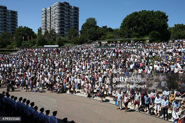 Spectators stand for a minutes silence, to pay tribute to the victims of last week's Tunisia beach attack, on Murray Mound during Wimbledon Lawn...