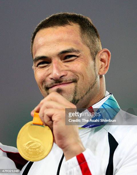 Gold medalist Koji Murofushi of Japan poses for photographs with his medal during the victory ceremony for the men's hammer throw final during day...