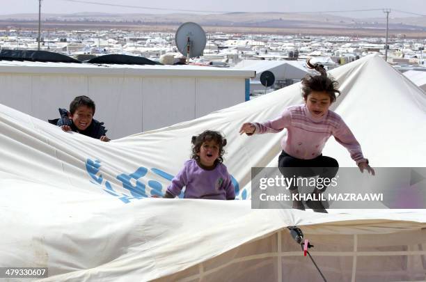 Picture taken on March 15, 2014 shows children playing at the sprawling desert Zaatari refugee camp in northern Jordan near the border with Syria...