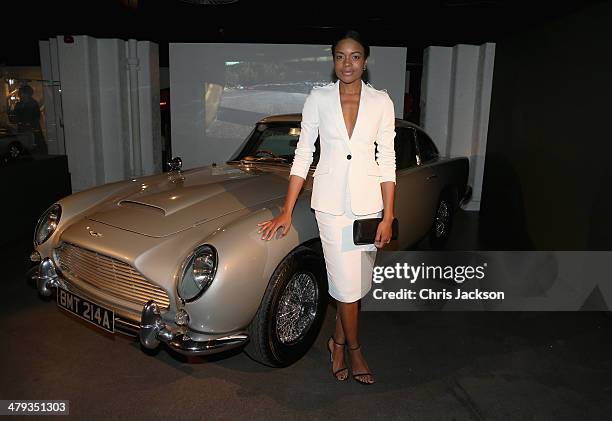 Actress Naomie Harris poses with the Aston Martin DB5 from 'Goldeneye' as she attends a drinks reception ahead of the opening of the Bond In Motion...