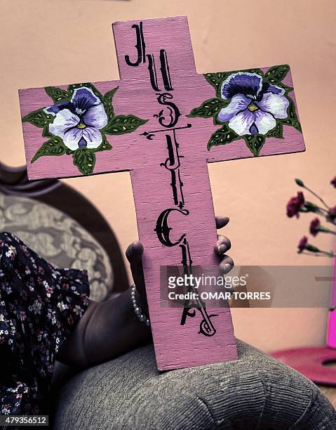 Irinea Buendia, mother of Mariana Lima Buendia, holds a cross reading "Justice" during an interview at her home in Nezahualcoyotl, Mexico state, on...
