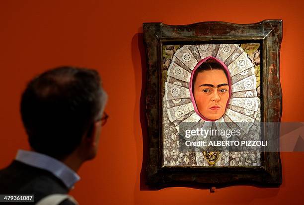 Visitor looks at the "Self-Portrait" painting by Mexican artist Frida Kahlo during an exhibition in Rome's Scuderie del Quirinale on March 18, 2014....