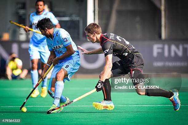 India's Yuvraj Walmiki and Belgium's Jerome Truyens vie for the ball during the men's semi-final match between Belgium and India at the Hockey World...