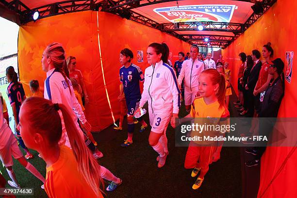 Azusa Iwashimizu of Japan and Claire Rafferty of England enter the pitch before the FIFA Women's World Cup Canada 2015 semi final match between...