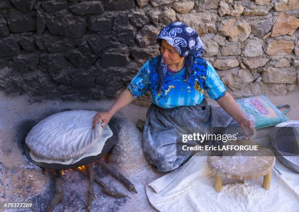 Woman making local bread in the old Kurdish village of Palangan at dusk, Iran, on September 19, 2013.