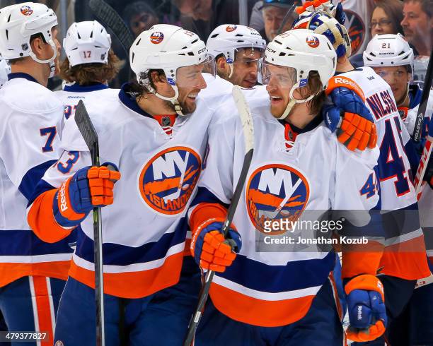Michael Grabner of the New York Islanders celebrates with teammate Colin McDonald after scoring the overtime winner against the Winnipeg Jets at the...