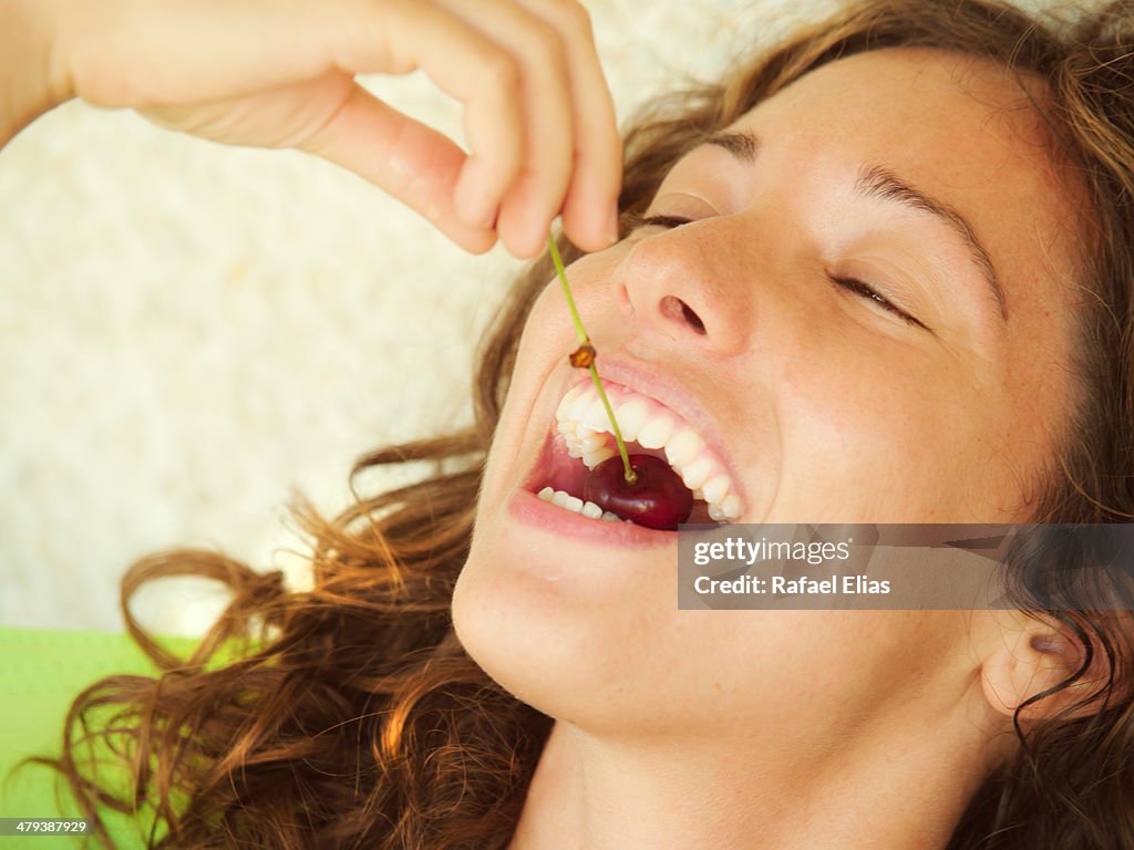 Pretty woman eating cherry
