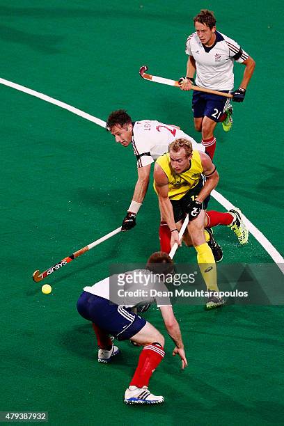 Aran Zalewski of Australia battles for the ball with Henry Weir , Iain Lewers and Tim Whiteman of Great Britain during the Fintro Hockey World League...