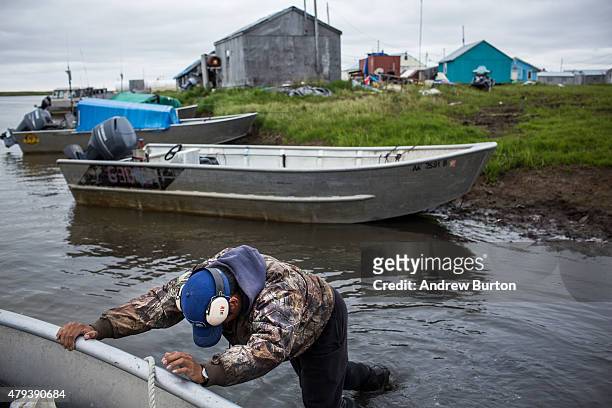 Jeremiah John helps push his father's boat into the water to go fishing for salmon on July 1, 2015 in Newtok, Alaska. Newtok has a population of...