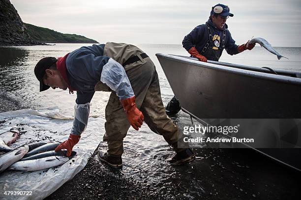 Joseph John Jr. Washes freshly caught salmon with his son, Jeremiah John, while waiting for the tide to come in on July 1, 2015 in Newtok, Alaska....