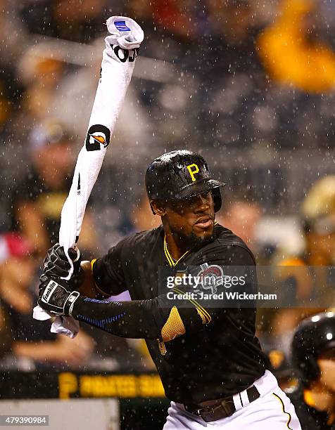 Starling Marte of the Pittsburgh Pirates warms up in the on deck circle with his bat covered in a Gatorade towel as the rain falls in the seventh...