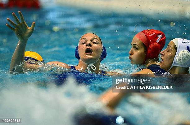 Italy's Roberta Bianconi is pushed down by Hungary's Gabriella Szucs and goalkeeper Orsolya Kaso in the local swimming pool of Budapest on March 18,...