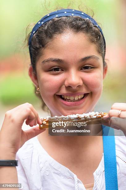 zwölf jahren hispanischen mädchen mit einem churro - 12 years old girls stock-fotos und bilder