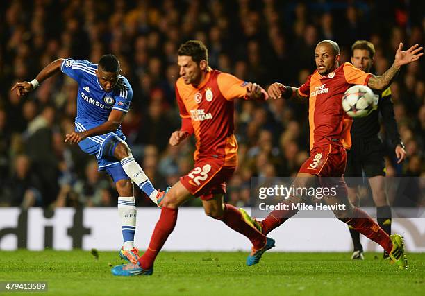 Samuel Eto'o of Chelsea shoots past Hakan Balta and Felipe Melo of Galatasaray during the UEFA Champions League Round of 16 second leg match between...
