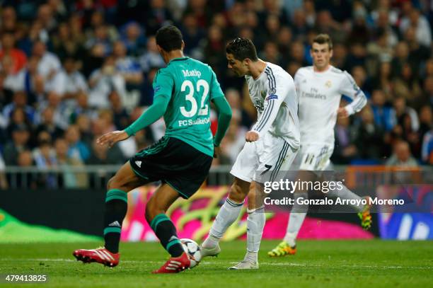 Cristiano Ronaldo of Real Madrid shoots past Joel Matip of Schalke to score his team's second goal during the UEFA Champions League Round of 16,...