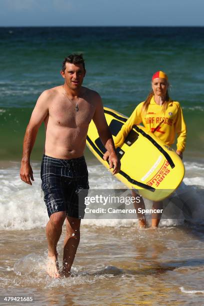 Drew Butera of the Los Angeles Dodgers walks out of the water after swimming with lifesaver Sophie Thomson during a Los Angeles Dodgers players visit...