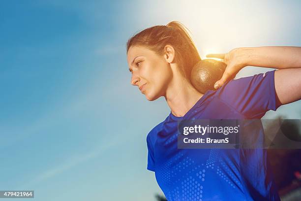 smiling woman in a shot put against the sky. - shot put stock pictures, royalty-free photos & images